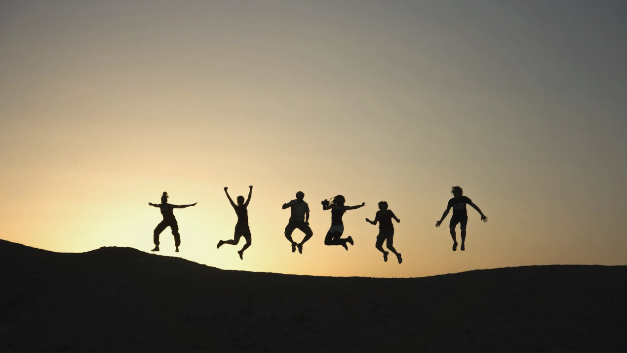 six silhouette of people jumping during sunrise